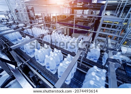 Modern strapping and transporting machine for packaging line at beverage plant.