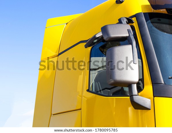 modern, streamlined\
truck cab with good aerodynamics with a rearview mirror. Yellow\
truck cab, background