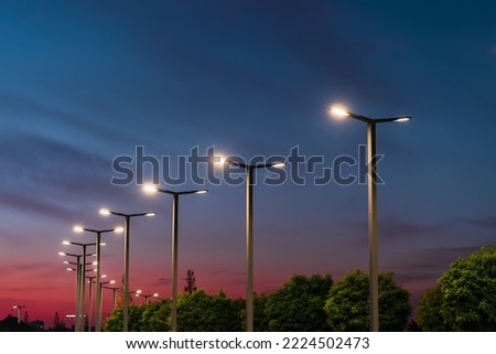 Modern street LED lighting pole. Urban electro-energy technologies. A row of street lights against the night sky