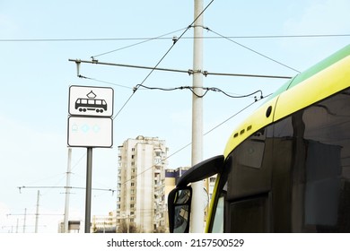 Modern streetcar near tram stop sign outdoors