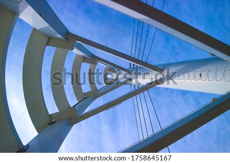 The modern structure of white metal steel line shape and cable of Suspension bridge( Saeyeongyo Bridge) isolated on blue sky, Jeju island, South korea.
