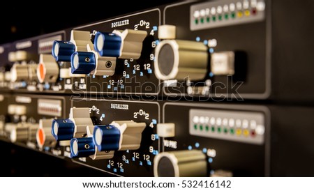 Modern Studio Gear, Equalizer, with a bunch of knobs in closeup and shallow depth of field.
