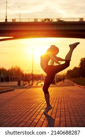 modern style dancer woman jumping. Dancer silhouette at sunset. Contour of girl on urban city background.