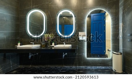 Modern style interior design of a wash basin on black granite counter in restroom