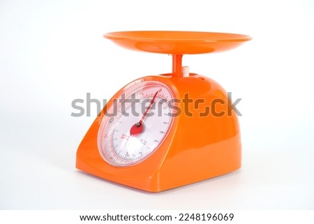 Modern style orange kitchen weight scale on white background