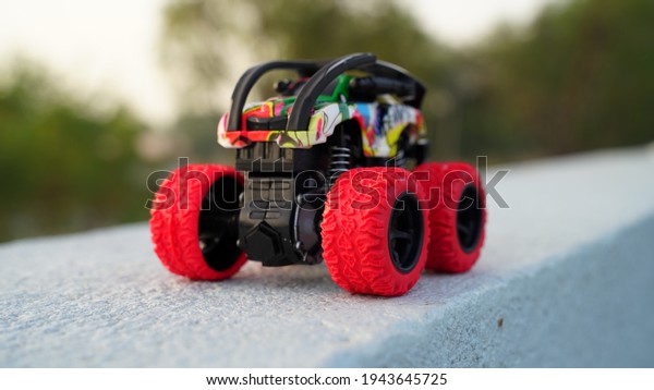 Modern style Super king truck toy with with remote\
control system. Plastic car toy with big wheels, holding on the\
cement floor.