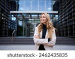 Modern stylish Caucasian adult business woman dressed in formal suit standing in work place outdoor. Strong and empowered female happy with shaved head looking smiling to the side. Copy space