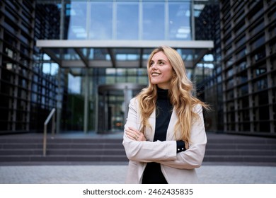 Modern stylish Caucasian adult business woman dressed in formal suit standing in work place outdoor. Strong and empowered female happy with shaved head looking smiling to the side. Copy space