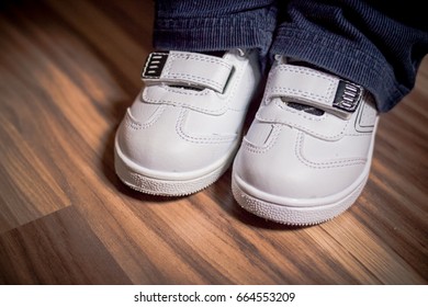  Modern Stylish Fashionable Trendy White Shoes For Children On Wooden Floor. Children's Shoes. Moccasins. Baby Treading Leather. Kid Shoe Or Child's Shoes, Boots.pair Of White Stylish Shoes For Child