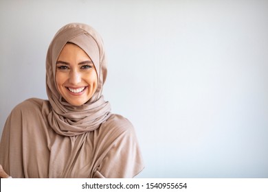 Modern, Stylish and Happy Muslim Woman Wearing a Headscarf. Arab saudi emirates woman covered with beige scarf. "Welcome" Face. One women smile with white background  - Shutterstock ID 1540955654