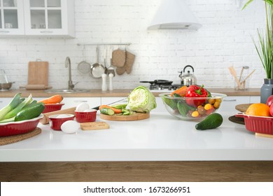 Modern stylish kitchen interior with vegetables and fruits on the table . Bright white kitchen with household items . The concept of a healthy lifestyle. - Shutterstock ID 1673266951