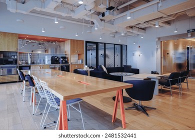 a modern, stylish office lounge area with an open layout. The space features contemporary furniture including a large black sofa with cushions, sleek armchairs with metal frames. - Powered by Shutterstock