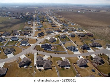 Modern suburban homes and farm fields in the midwestern United States.