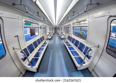 Modern subway metro train inside interior, empty public transport with blue seats. Wagon with open doors in the depot