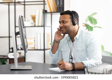 Modern successful Indian businessman in headset is negotiating with multiracial business partners by videoconference using a laptop, Business meeting online concept
