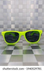 Modern Sunglasses With Yellow Frame On The Theme Of Sun And Holidays With Metal Background From Different Surfaces To Look Forward To Spring And Summer. Vertical