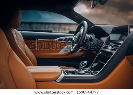 Modern supercar interior with the leather panel, sport seats, multimedia, and digital dashboard. Interior of an expensive coupe. Cozy and stylish cockpit of coupe car