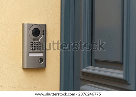A modern surveillance camera is installed on the front door. Close-up.
