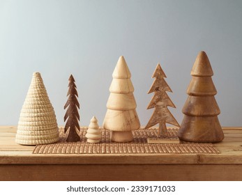 Modern sustainable Christmas decoration concept. Wooden Christmas trees on table over gray wall background. - Powered by Shutterstock