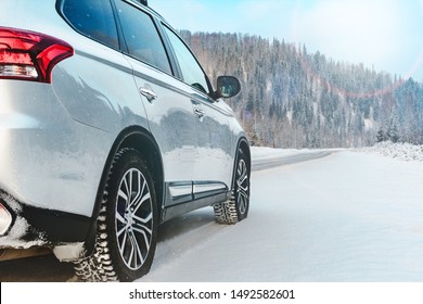 Modern Suv car stay on roadside of winter road. Family trip to ski resort concept. Winter or spring holidays adventure. car on winter snowy road in mountains