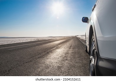 Modern SUV On The Side Of A Winter Road On A Sunny Day. Family Travel Concept To Ski Resort. Winter Or Spring Break. Car On A Winter Snowy Road In The Mountains. Copy Space.