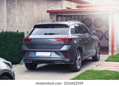 Modern SUV parked in front of a garage. High quality photo - Shutterstock ID 2316422559