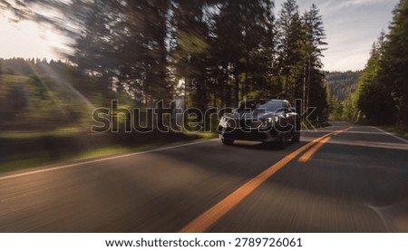 Modern suv speeding through a forest road with motion blur at sunset