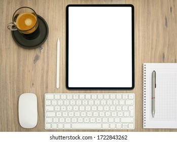 Modern tablet computer, pen, notebook, coffee cup, keyboard, mouse and digital pencil on office table. Home office.