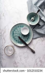 Modern Tableware From Above. Empty Glass, Plate And Bowls With Napkin On Marble Counter. Copy Space.