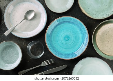 Modern Tableware Set With Cutlery And A Vibrant Blue Plate, Overhead Flat Lay Shot On A Black Slate Background