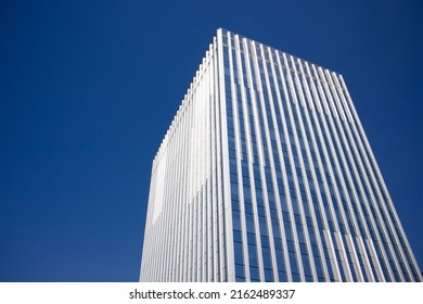 Modern tall multistory building glass facade against blue sky with space for text. Construction of residential buildings, office buildings, facilities. Construction business. Real estate investment.
