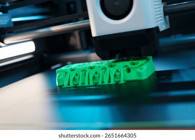 In a modern tech workshop, a 3D printer operates, meticulously crafting a vivid green object. The intricate design takes shape layer by layer, showcasing advanced printing technology.