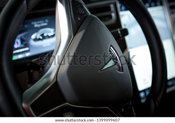 Modern Technologies\
in Tesla Electromobile. Close-Up Steering Wheel with Metal Elon\
Musk\'s Tesla Emblem. Future Vehicle. Kyiv, Ukraine, F-Drive\
showroom 13 of february\
2018.