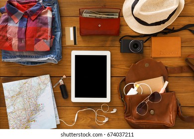 Modern technologies and vacation concept. Set of tourist personal stuff with tablet with blank screen, mockup. top view.