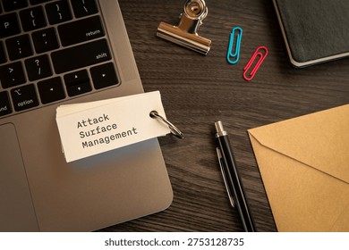 Modern technology concept of Attack Surface Management on word card with laptop, clips, pen. Digital innovation and connectivity visualization.