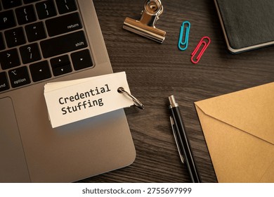 Modern technology concept of Credential Stuffing on word card with laptop, clips, pen. Digital innovation and connectivity visualization.