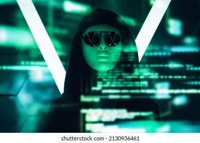 A modern teen boy in a black hoodie, mask and black sunglasses hiding his face looks at holographic data on virtual screen. Studio shot among neon lights. Teen hacker in cyberspace. 