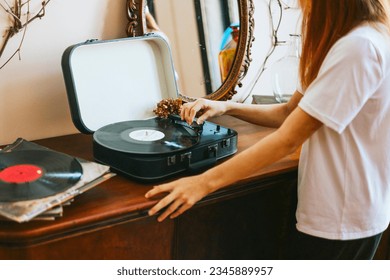modern teenage girl with dyed hair turns on a retro record player, meeting modern with retro