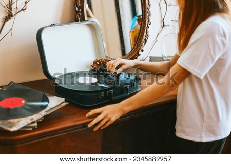 modern teenage girl with dyed hair turns on a retro record player, meeting modern with retro