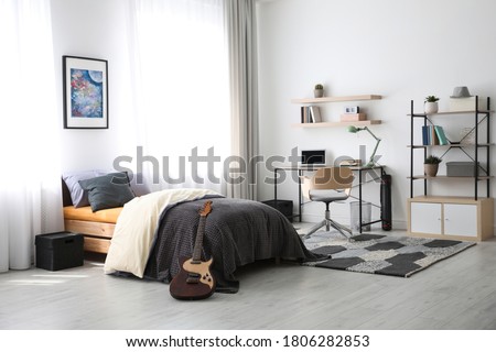 Modern teenager's room interior with workplace and bed