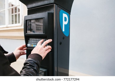 A modern terminal for paying for car parking. The person presses the buttons and pays for the parking. Modern technology in everyday life.