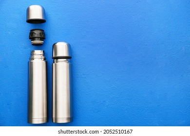 Modern thermoses on color background