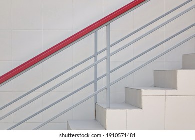 Modern Tiled Staircase Or Stairway With Iron Guard Hand Railing At The White Wall Background. Side View. Selective Focus.