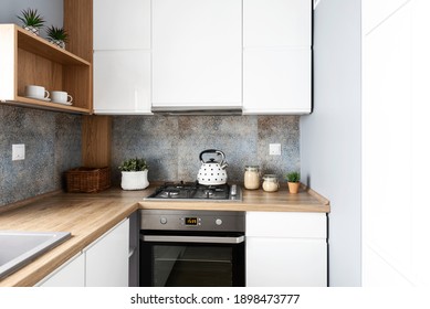 Modern Tiles Pattern In Small Bright Kitchen In Apartment. White Furniture Cabinets And Wooden Counter Top With Oven And Kettle. Scandinavian Design. Nobody.