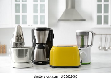 Modern toaster and other home appliances on white marble table in kitchen - Shutterstock ID 1925622083