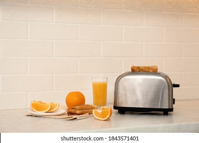 Modern Toaster And Tasty Breakfast On Counter In Kitchen