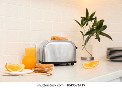 Modern Toaster And Tasty Breakfast On Counter In Kitchen