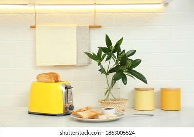 Modern Toaster And Tasty Breakfast On Counter In Kitchen