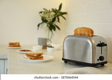 Modern Toaster And Tasty Breakfast On Counter In Kitchen