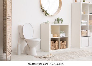 Modern Toilet Bowl Near White Wall In Bathroom